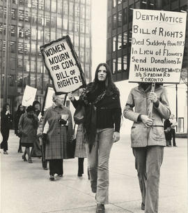 Women holding “Women mourn for Canadian Bill of Rights!” and “Death Notice: Bill of Rights died s...