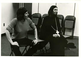 Two unidentified women sitting on chairs