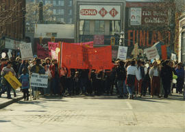 View from Sona HI FI storefront of participants carrying a "Aboriginal Women, the Strength of Nat...
