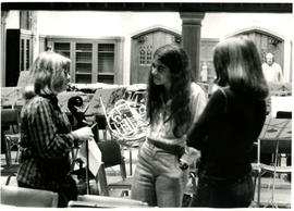 Three women talking, holding their cello and French horn during a poetry reading rehearsal, [Guelph]