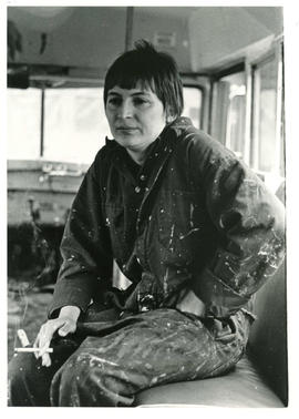 Judith Quinlan sitting and smoking while painting in the CORA Bookmobile